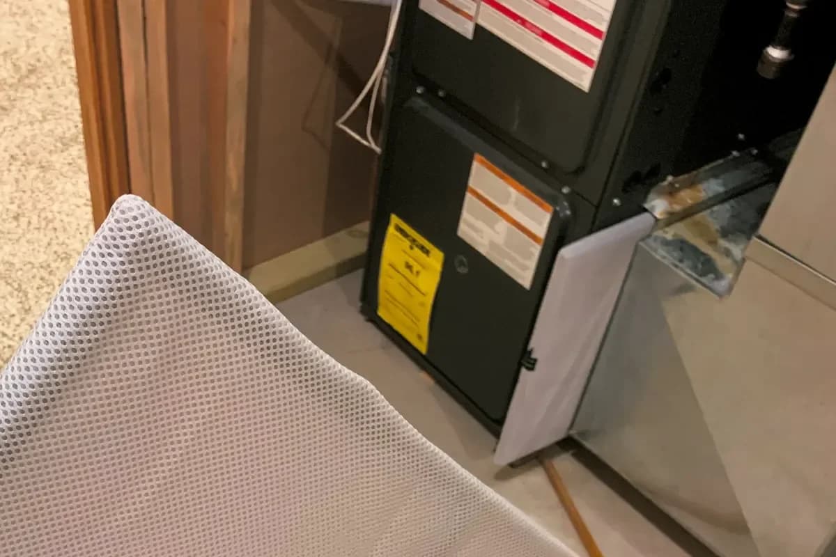 Removable air filter beside a furnace cabinet and connected ductwork